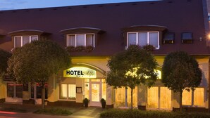 Un hôtel doté d’une enseigne bien visible, de grandes fenêtres et d’une entrée bien éclairée.