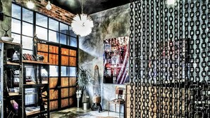 A room with exposed brick walls, large windows, a bookshelf, a plant, and a chain-link partition. - SuB Karaköy - Special Class (Istanbul)