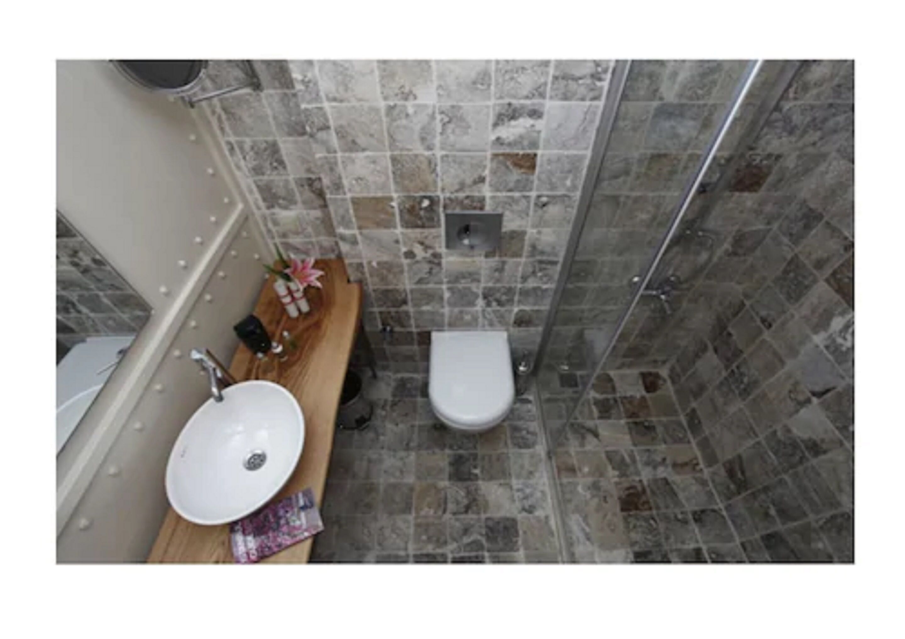 A bathroom with a white sink, a toilet, and a shower area.