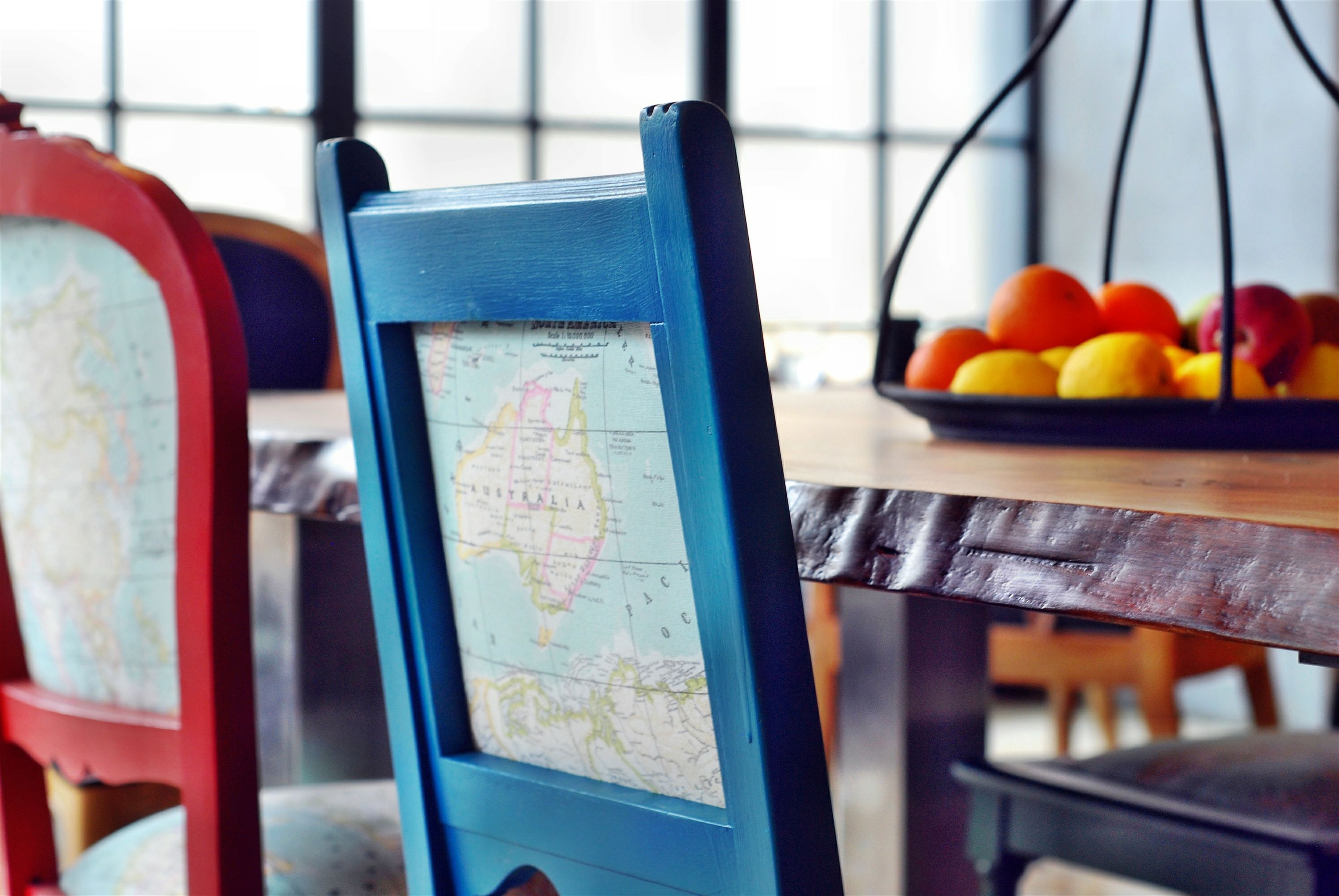 A dining table with a map and a fruit bowl.