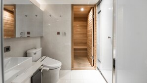 Een moderne badkamer met toilet, wastafel en houten lambrisering.