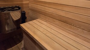Een sauna met houten latten op de wanden en een bank.
