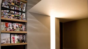 A hallway with a wall-mounted magazine rack and a tiled floor. - Saual Keh Hotel (Taipei)