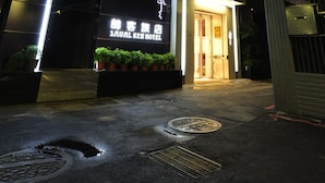 A hotel with a prominent sign, a well-lit entrance, and a modern facade. - Saual Keh Hotel (Taipei)