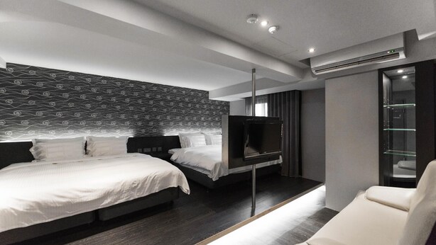 A modern hotel room with a large bed, a TV, and a seating area. - Saual Keh Hotel (Taipei)