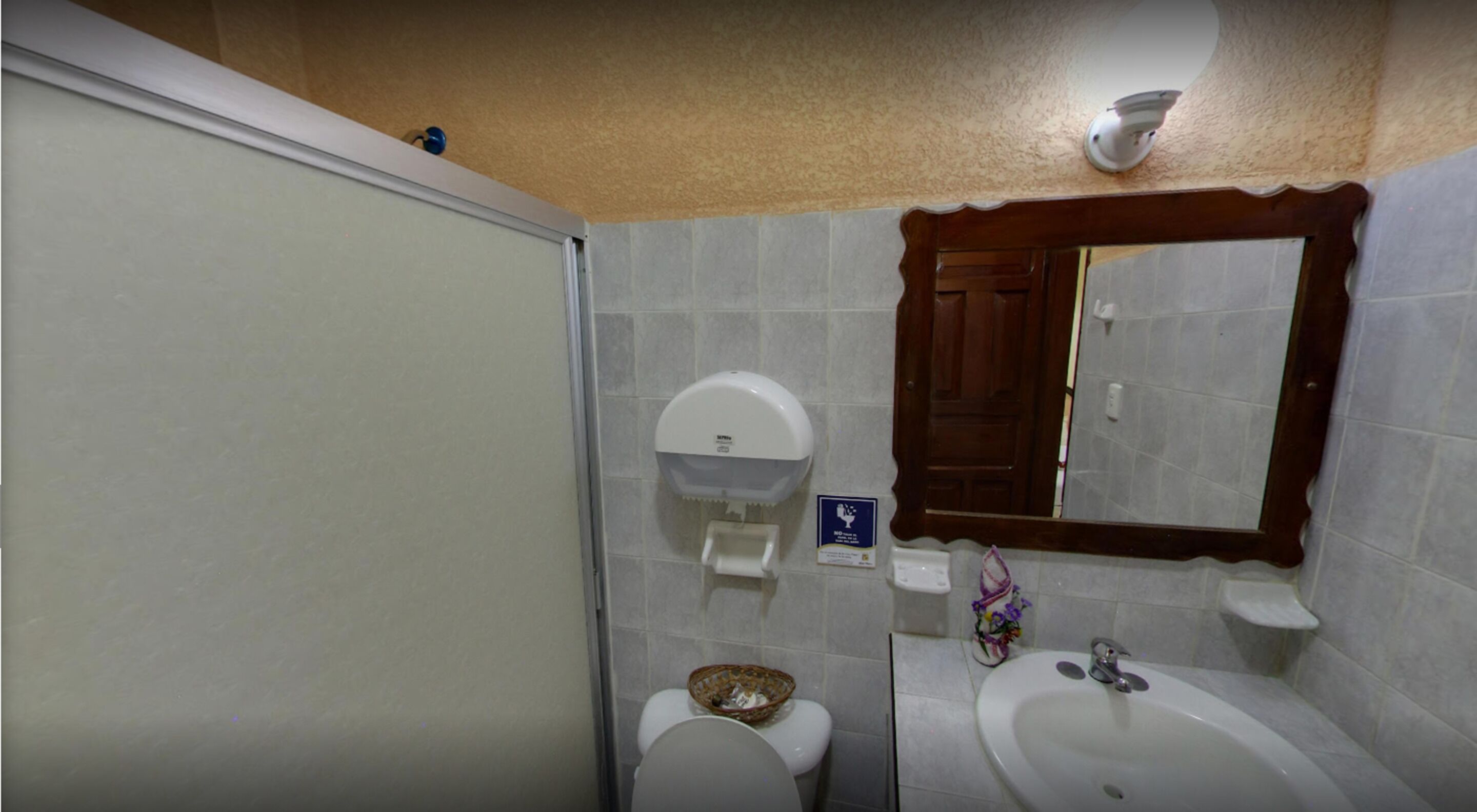 Een badkamer met toilet, wastafel en douche.