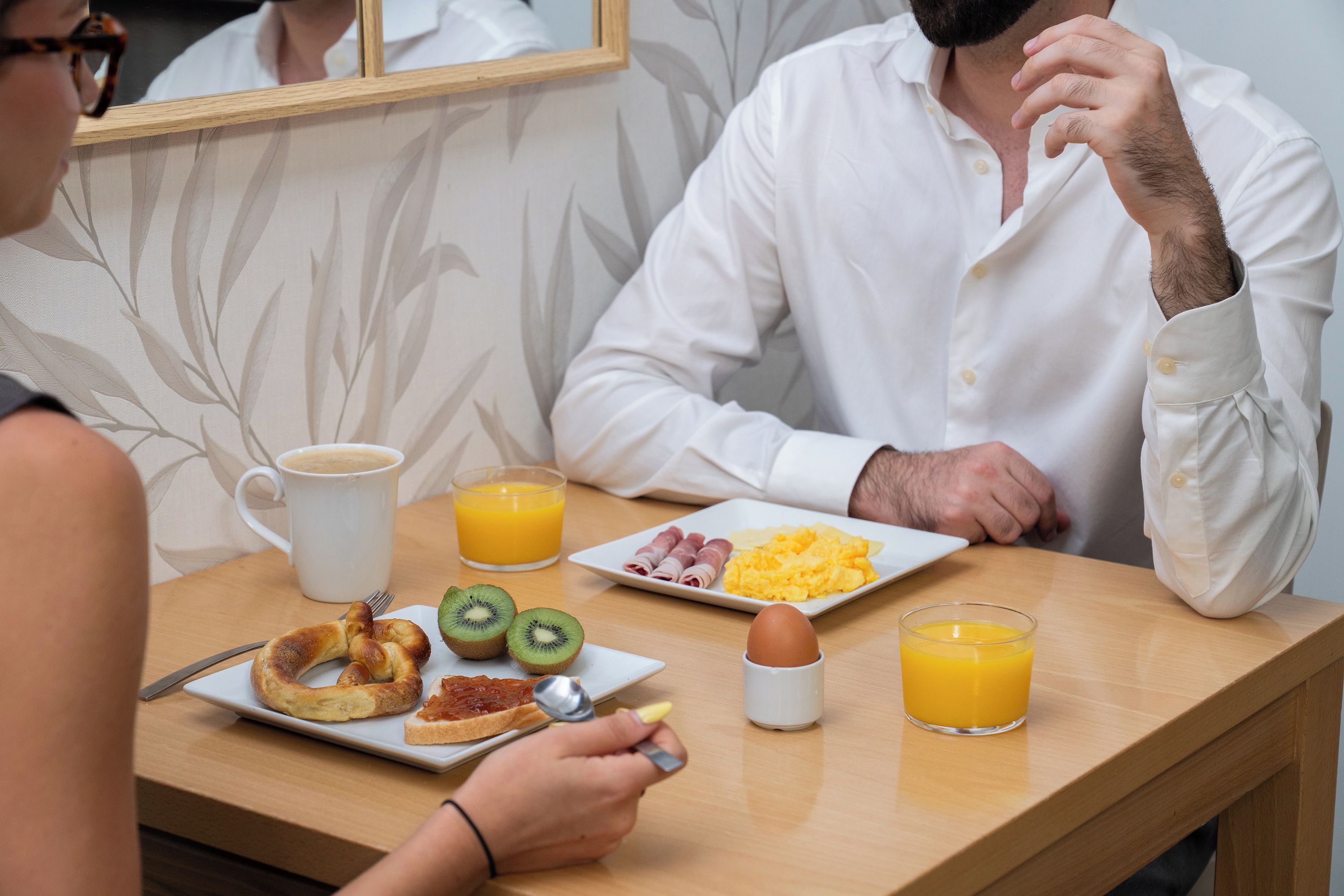 Un desayuno con un plato de comida, una taza de café y un vaso de jugo de naranja sobre una mesa de madera.