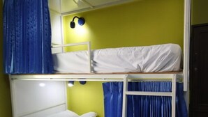 A bunk bed room with two levels, a ladder, and a wall-mounted lamp. - Nomads Chalong Beach, Phuket (Rawai)