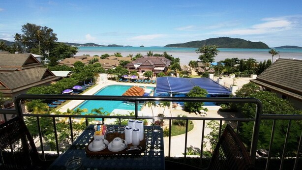 A resort with a pool, beach, and mountain views. - Nomads Chalong Beach, Phuket (Rawai)