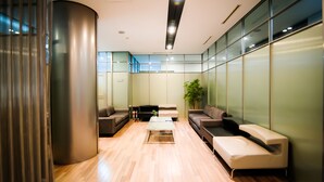 A modern waiting area with a wooden floor, a central coffee table, and two sofas. - Yoido Hotel (Seoul)