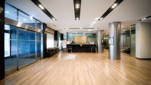 A modern lobby with a wooden floor, glass walls, and a reception desk. - Yoido Hotel (Seoul)