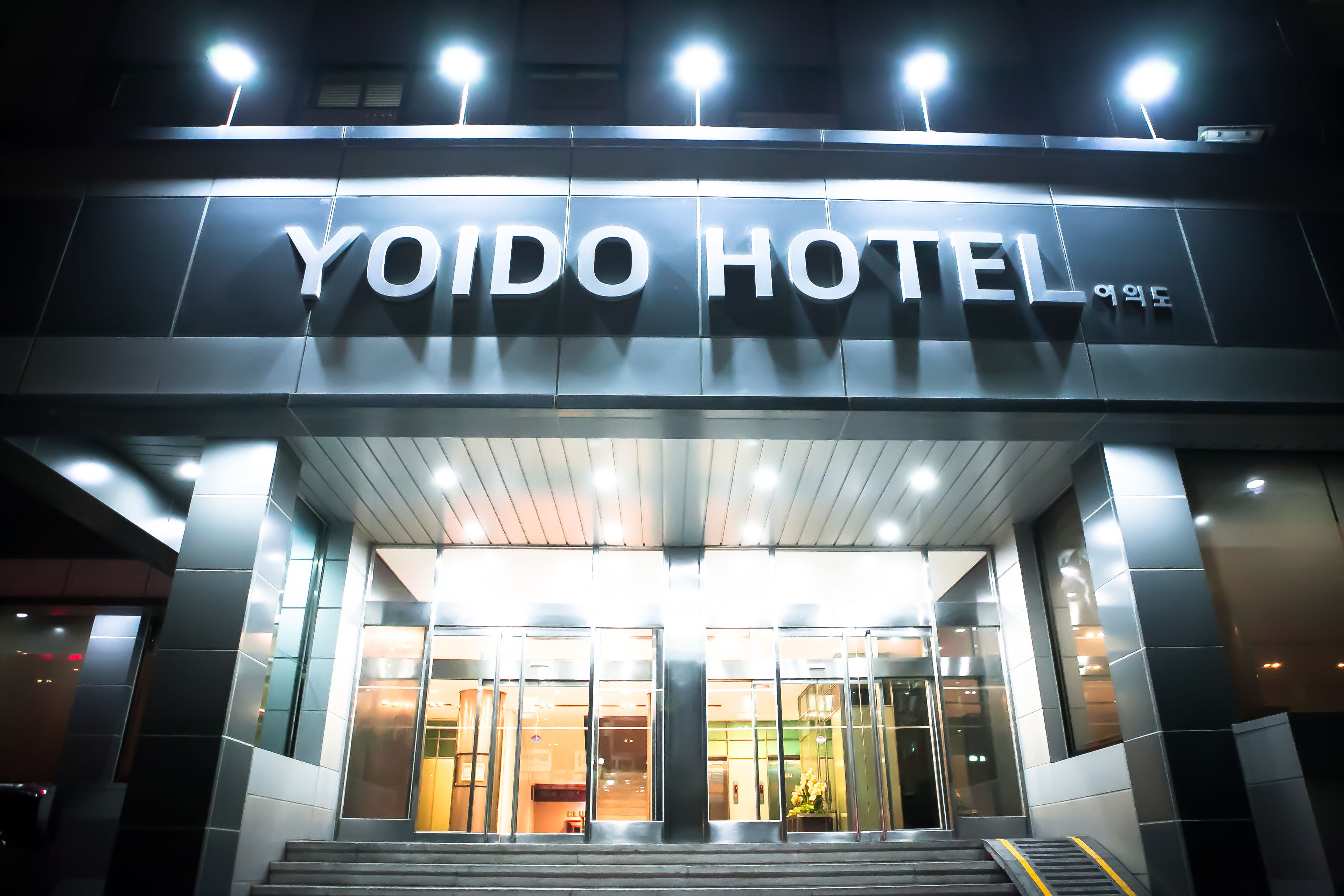 The exterior of the Yoido Hotel with a modern design, featuring large glass windows and a prominent entrance.