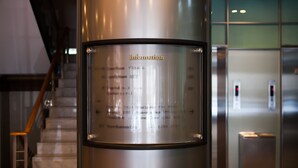 A metallic information panel with room names and directions in a hotel setting. - Yoido Hotel (Seoul)