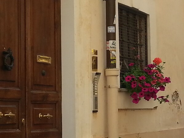 Una puerta de madera con manija de latón y una ventana con reja de metal.
