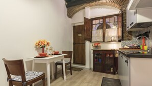 Una cocina compacta con una mesa de comedor, sillas y un mueble pequeño.