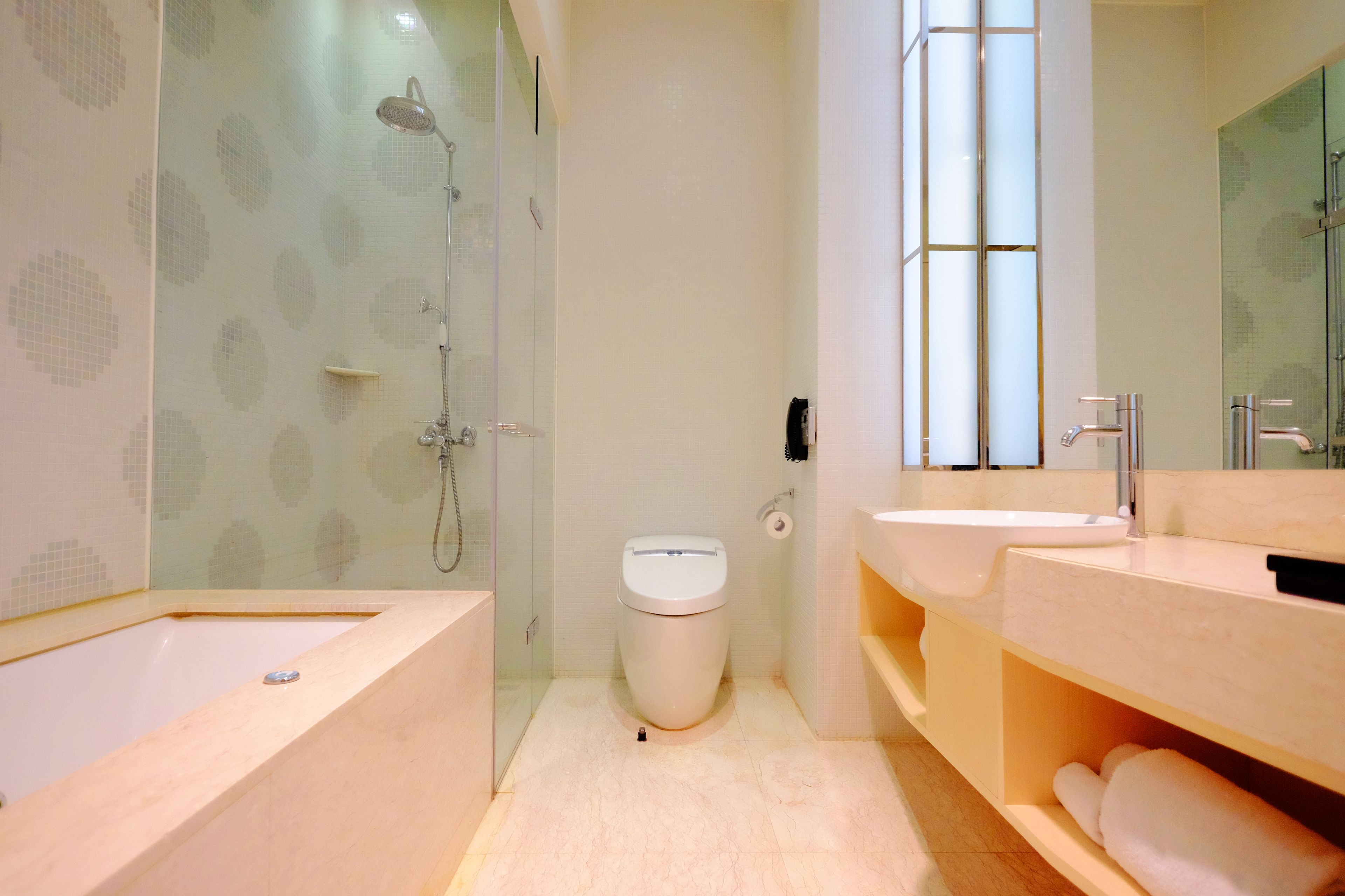 A modern bathroom with a bathtub, a toilet, and a sink.