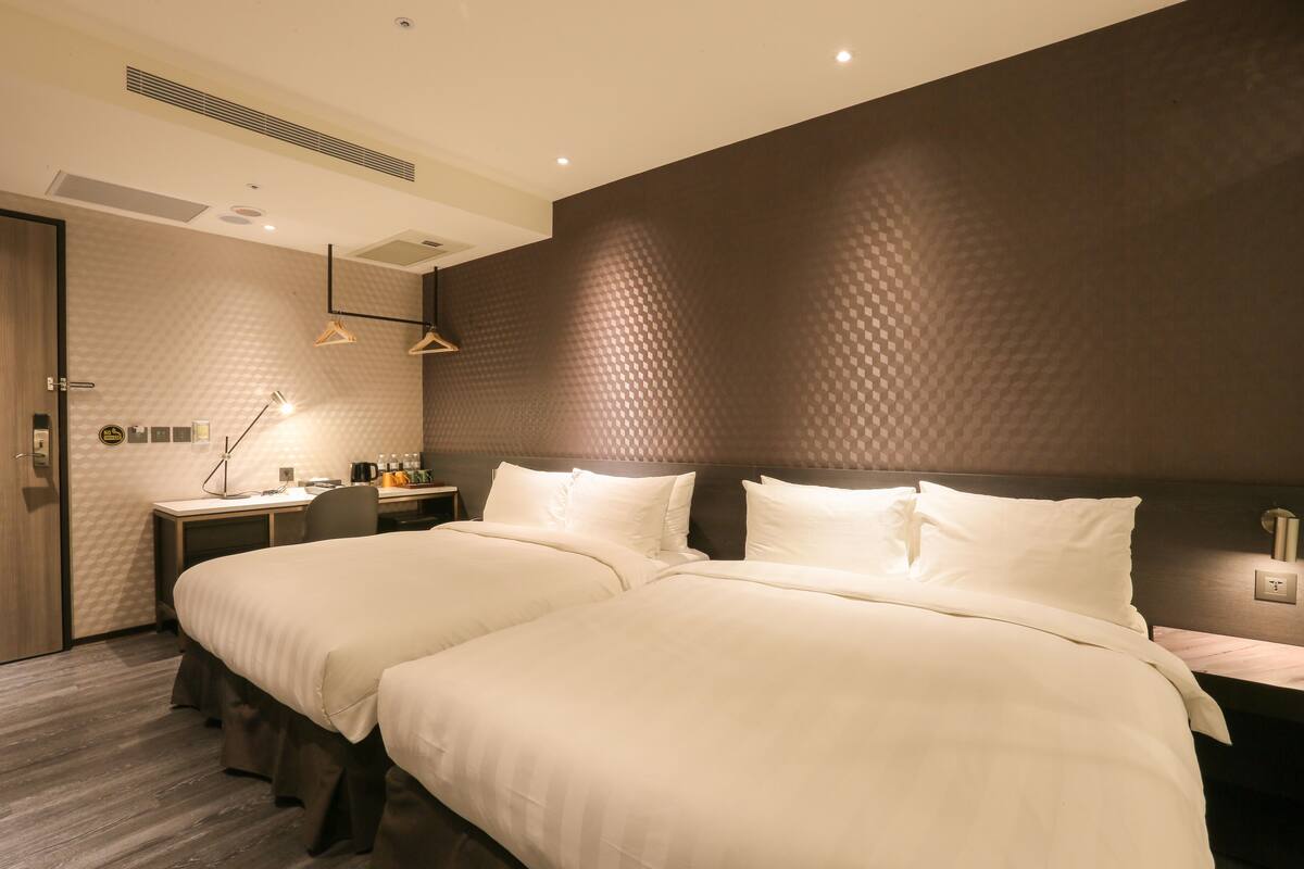 Ein modernes Hotelzimmer mit einem großen Bett, einem Schreibtisch und einem Sessel.
