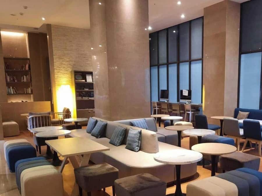 Een moderne zithoek met banken, tafels en een open haard.