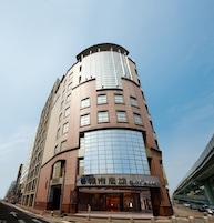 Un edificio alto y moderno con fachada curva y ventanas grandes.