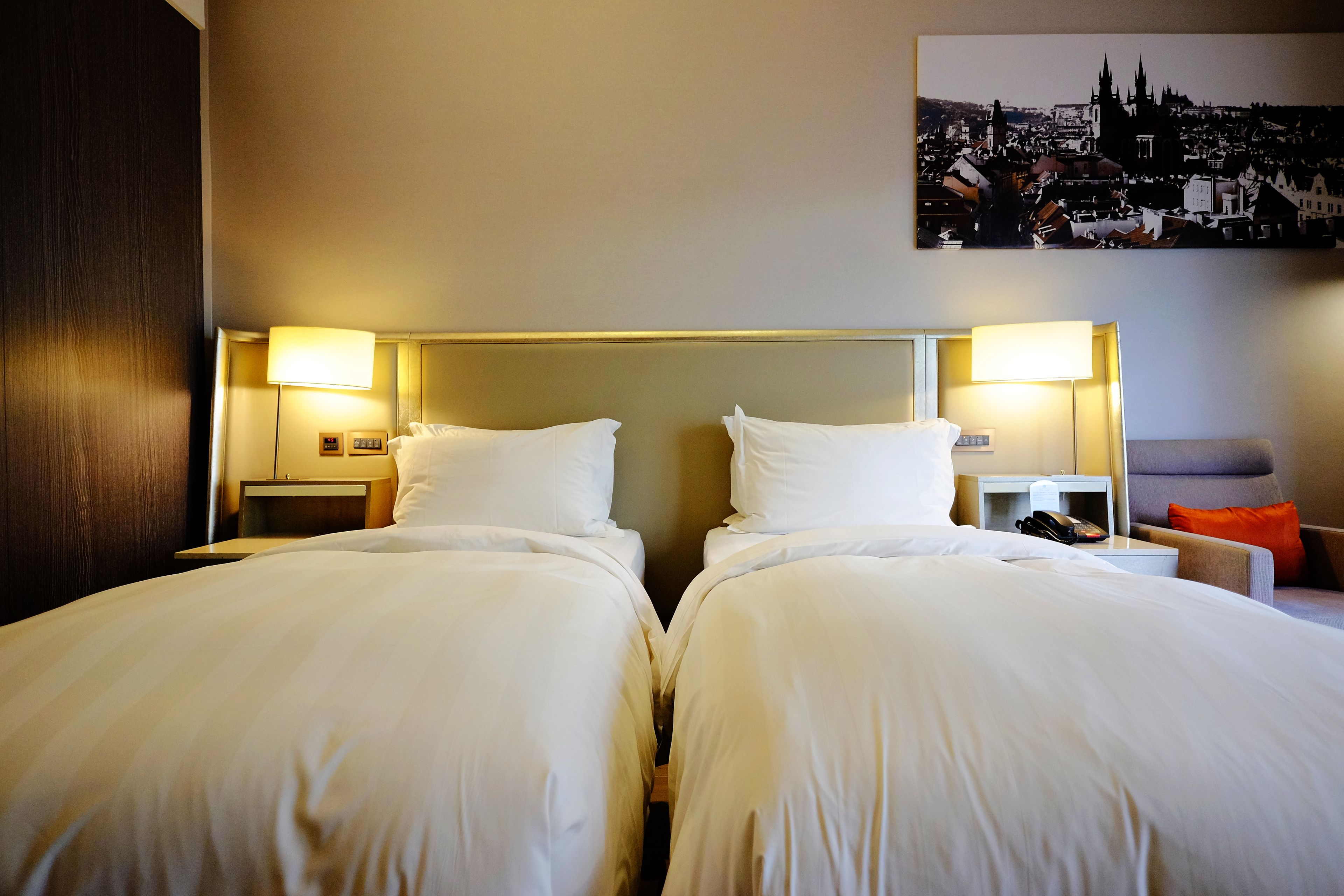 A hotel room with two beds, nightstands, a desk, and a chair.