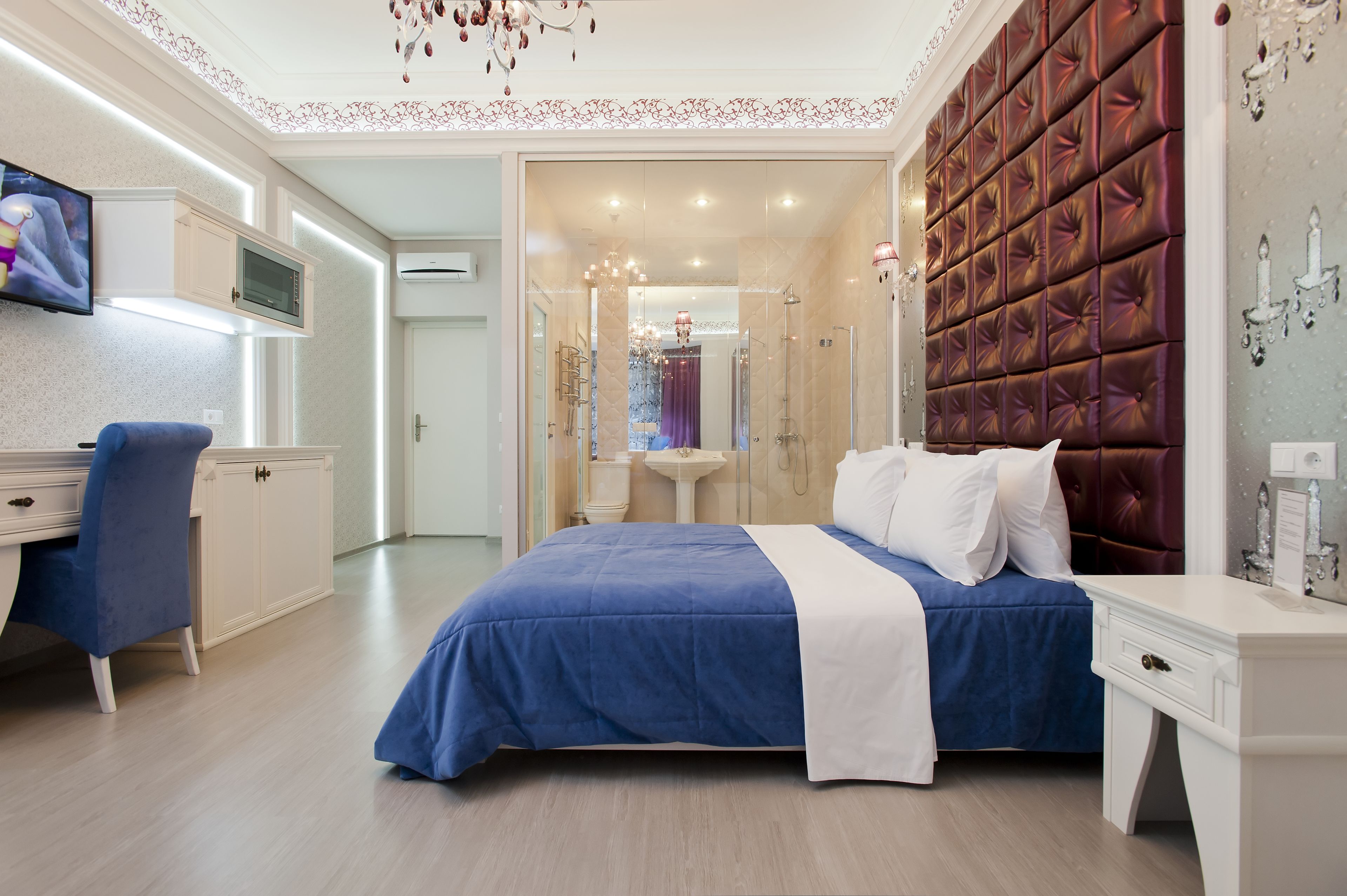 Un dormitorio moderno con una cama grande, un escritorio y una televisión.