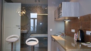 A modern kitchen with a sink, countertop, and a kettle. - Partner Guest House Khreschatyk (Kyiv)