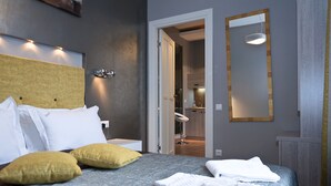 A neatly made bed with pillows, a bedside table, and a mirror on the wall. - Partner Guest House Khreschatyk (Kyiv)