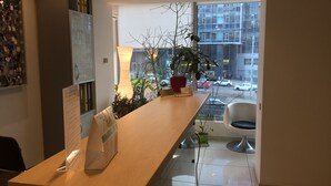 A reception desk with a menu, a potted plant, and a view of the street outside. - Partner Guest House Khreschatyk (Kyiv)