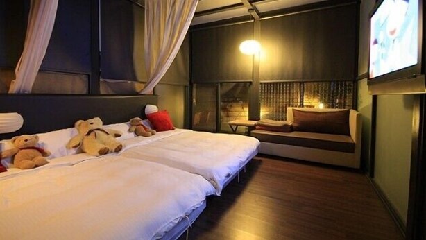 A hotel room with two beds, a TV, a bedside table, and a window with curtains. - Tanxiang Resort Hotel Sun Moon Lake (Yuchi)