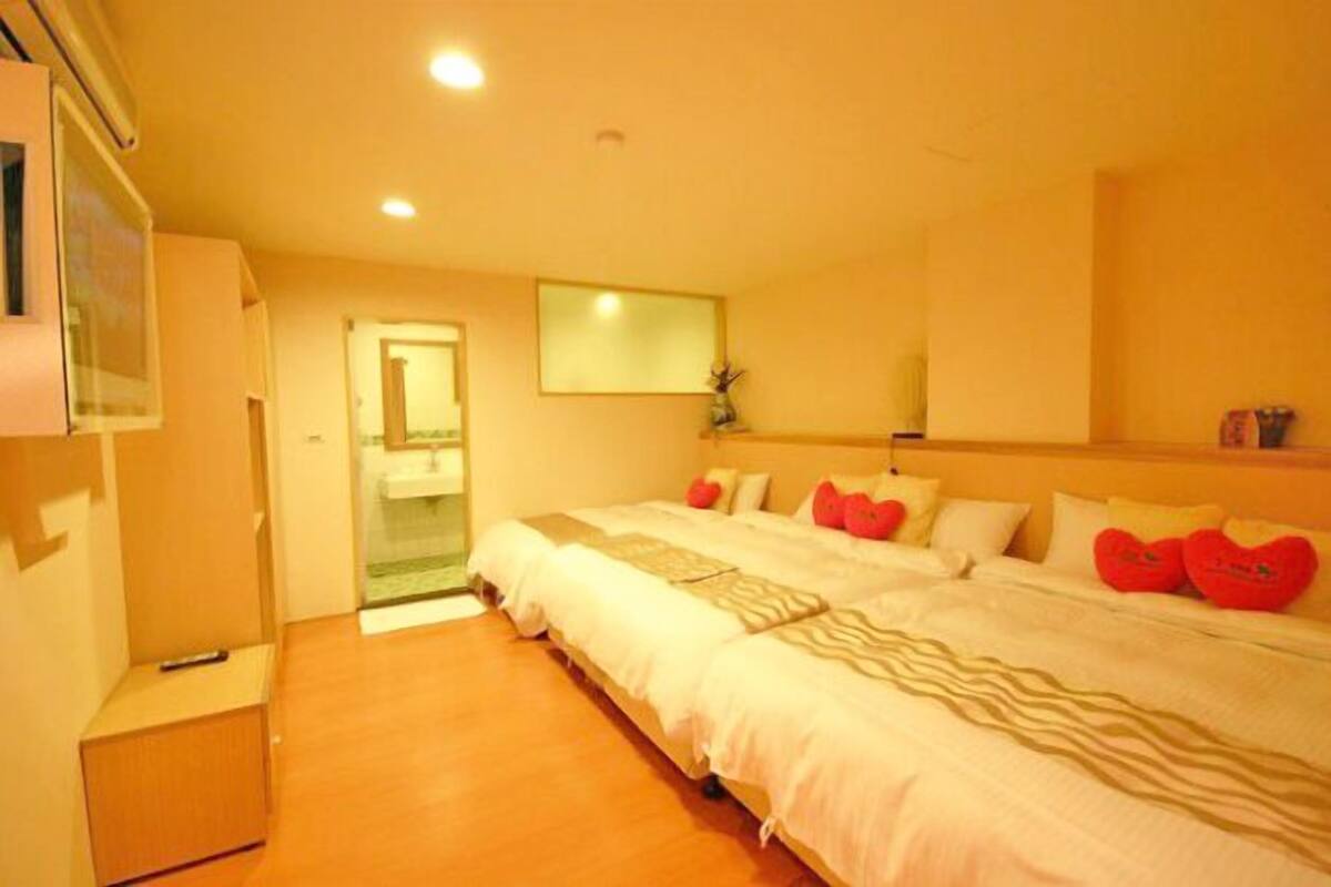 Een hotelkamer met een groot bed, een klein bureau en een spiegel aan de muur.