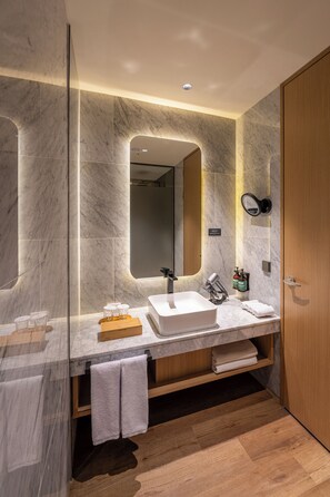 A modern bathroom with a marble vanity, a large mirror, and a wooden door. - voco Seoul Gangnam by IHG (Seoul)