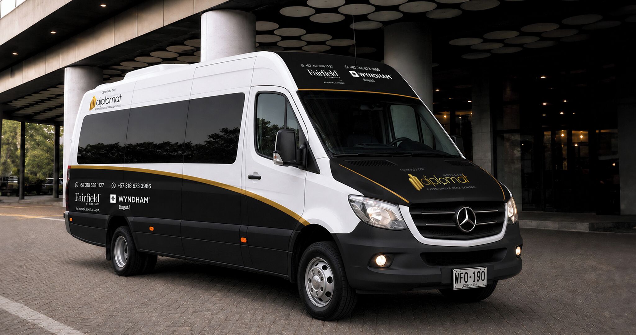 A white and black van with 'Fairfield' and 'Wyndham' branding, parked in front of a building with circular light fixtures.