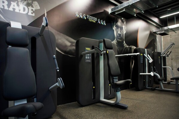 Un gimnasio con equipo de ejercicio y un gran mural en la pared.