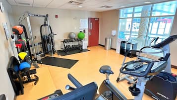 A gym with cardio machines, weightlifting equipment, and exercise balls.