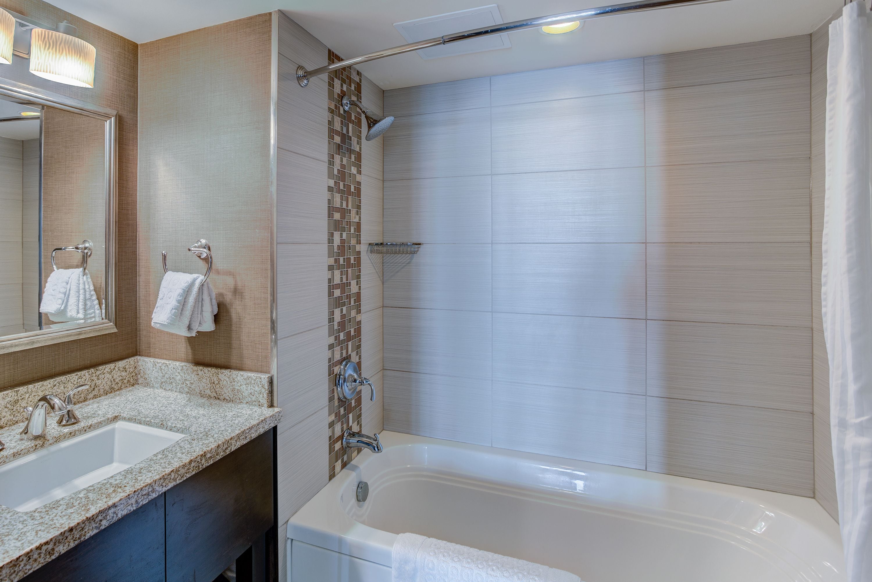 Une salle de bain moderne avec une grande baignoire, un lavabo et un espace douche.