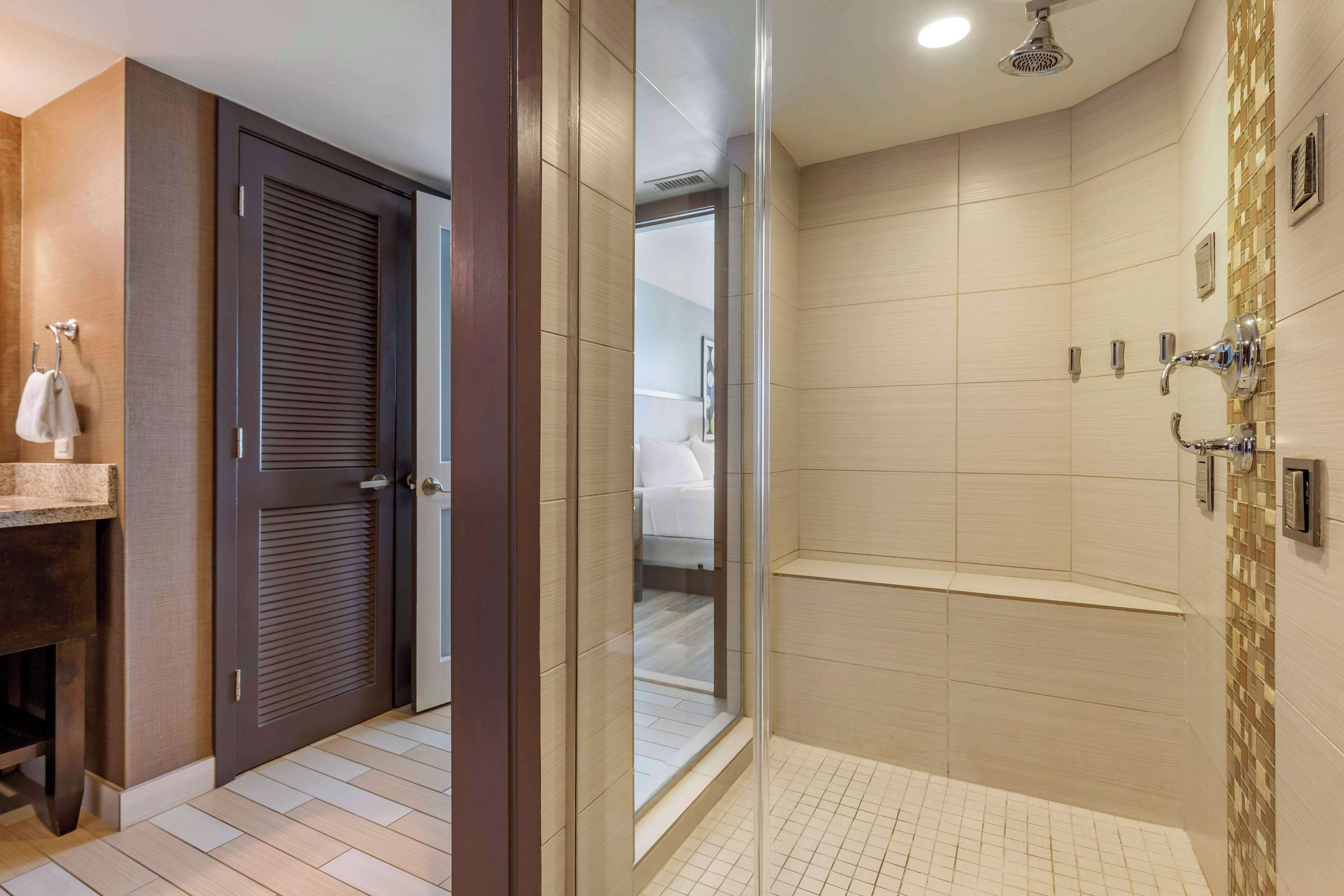 A modern bathroom with a shower, a toilet, and a sink.