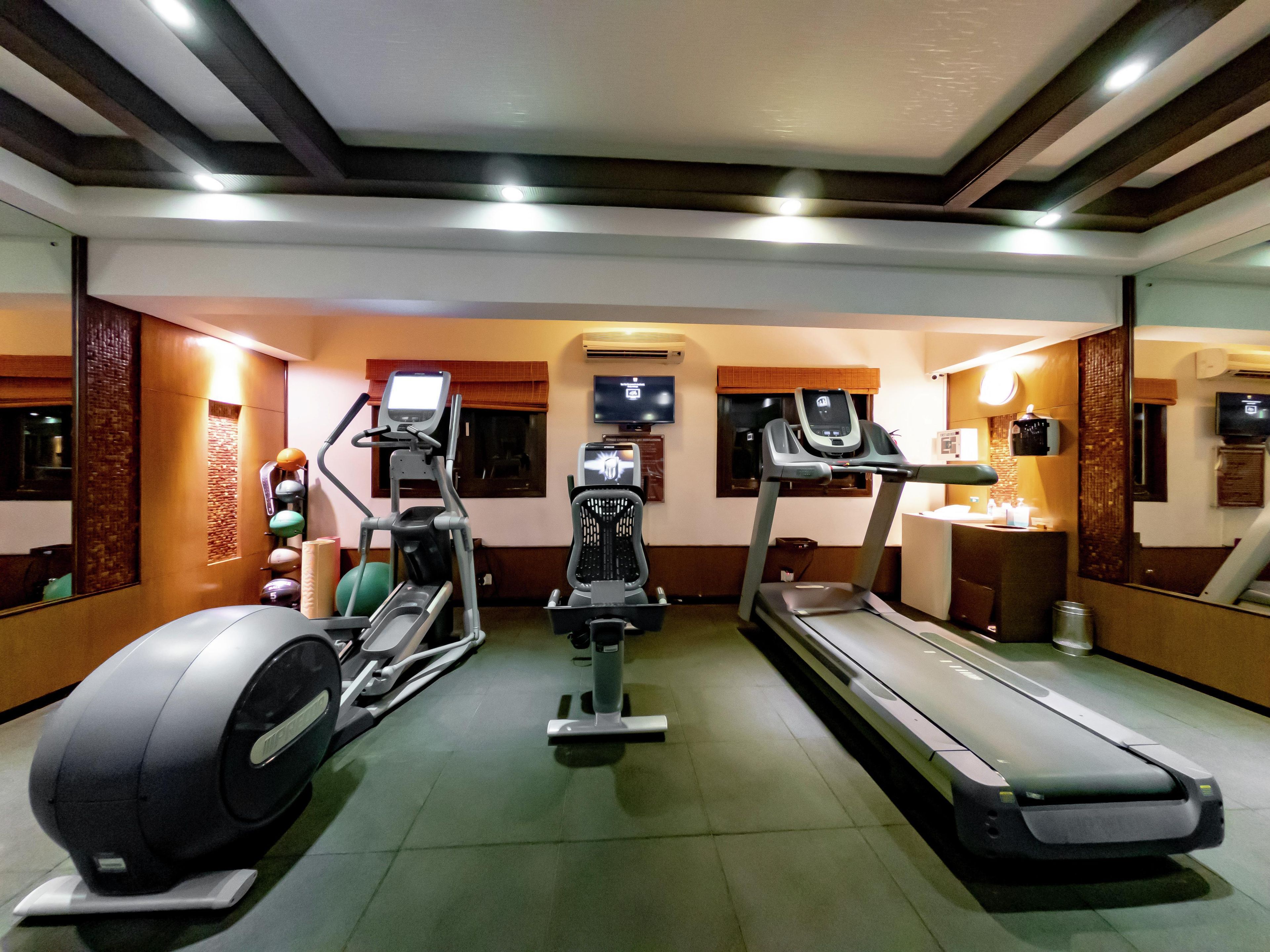 A gym with treadmills, an elliptical, and a stationary bike.