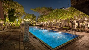 A rectangular swimming pool with a tiled edge, surrounded by stone pillars and benches. - Oakwood Hotel & Apartments Taman Mini Jakarta (Jakarta)