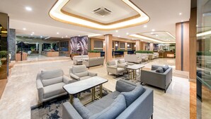 A spacious lobby with multiple seating areas, a reception desk, and a large mural. - Oakwood Hotel & Apartments Taman Mini Jakarta (Jakarta)