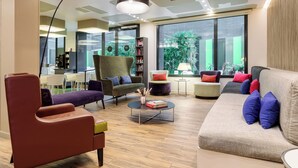 Uma sala de estar moderna com sofá, poltronas, mesa de centro e estante.