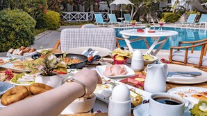 A poolside breakfast setup with various dishes, a dining table, and lounge chairs. - Moonshine Hotel & Suites (Bodrum)