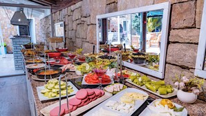 A buffet with various food items and a stone wall. - Moonshine Hotel & Suites (Bodrum)