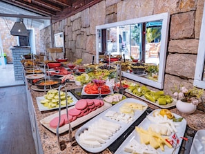 A buffet with various food items and a stone wall. - Moonshine Hotel & Suites (Bodrum)