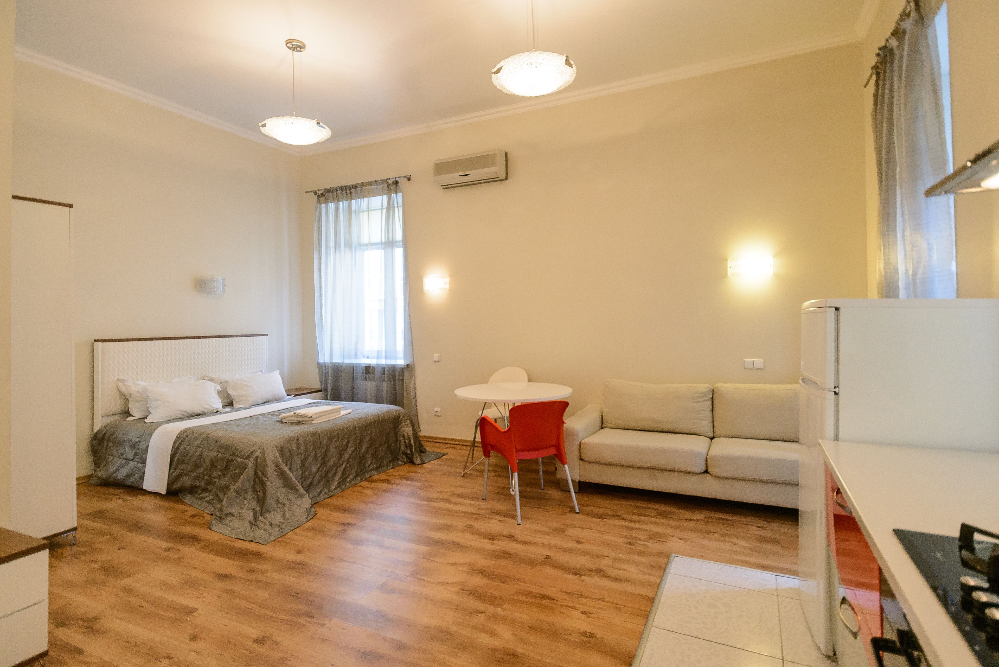 Ein Schlafzimmer mit einem Bett, einem kleinen Tisch, einer Couch und einer Küchenzeile.
