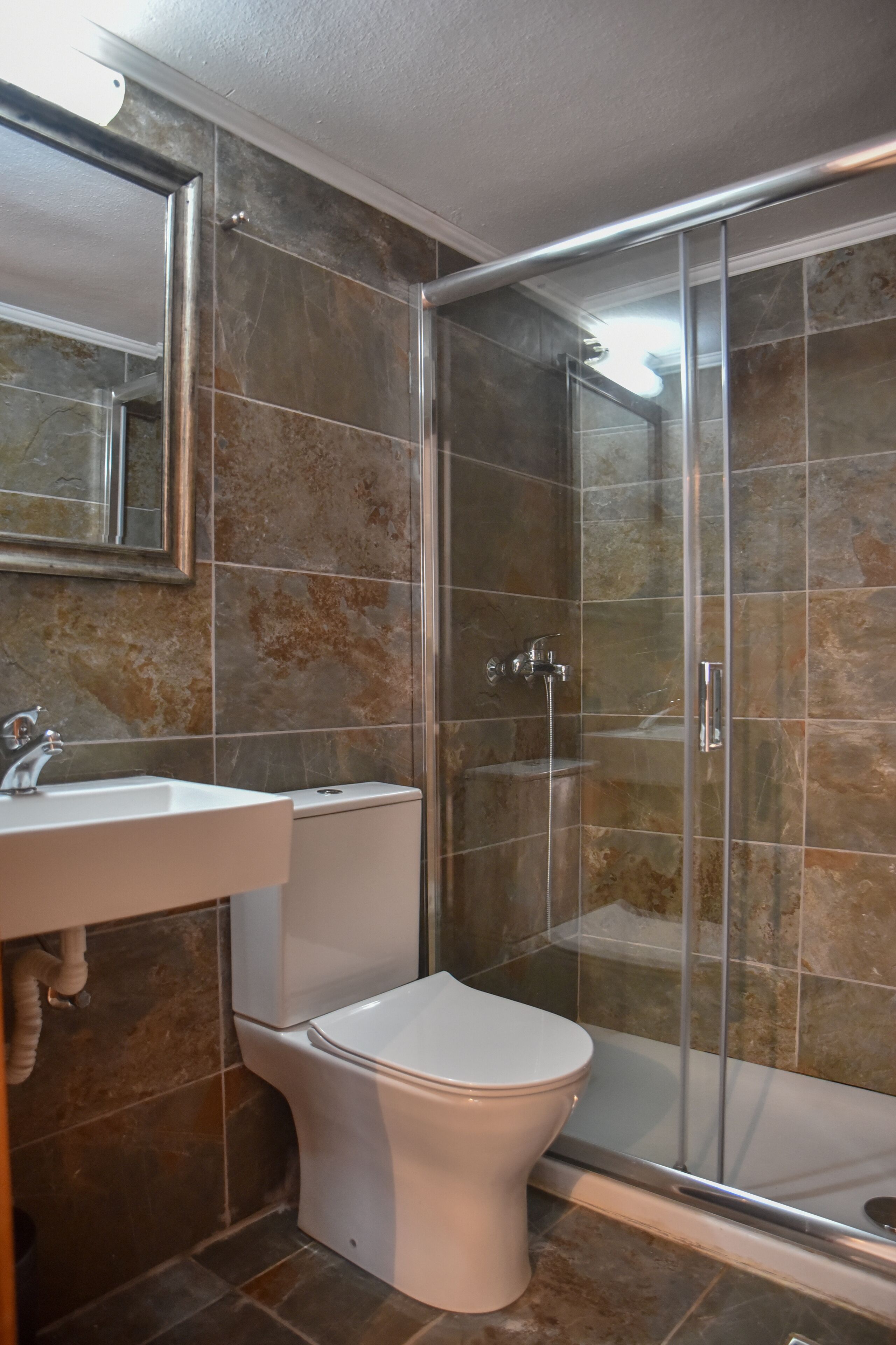 Un baño con ducha, inodoro y lavabo.