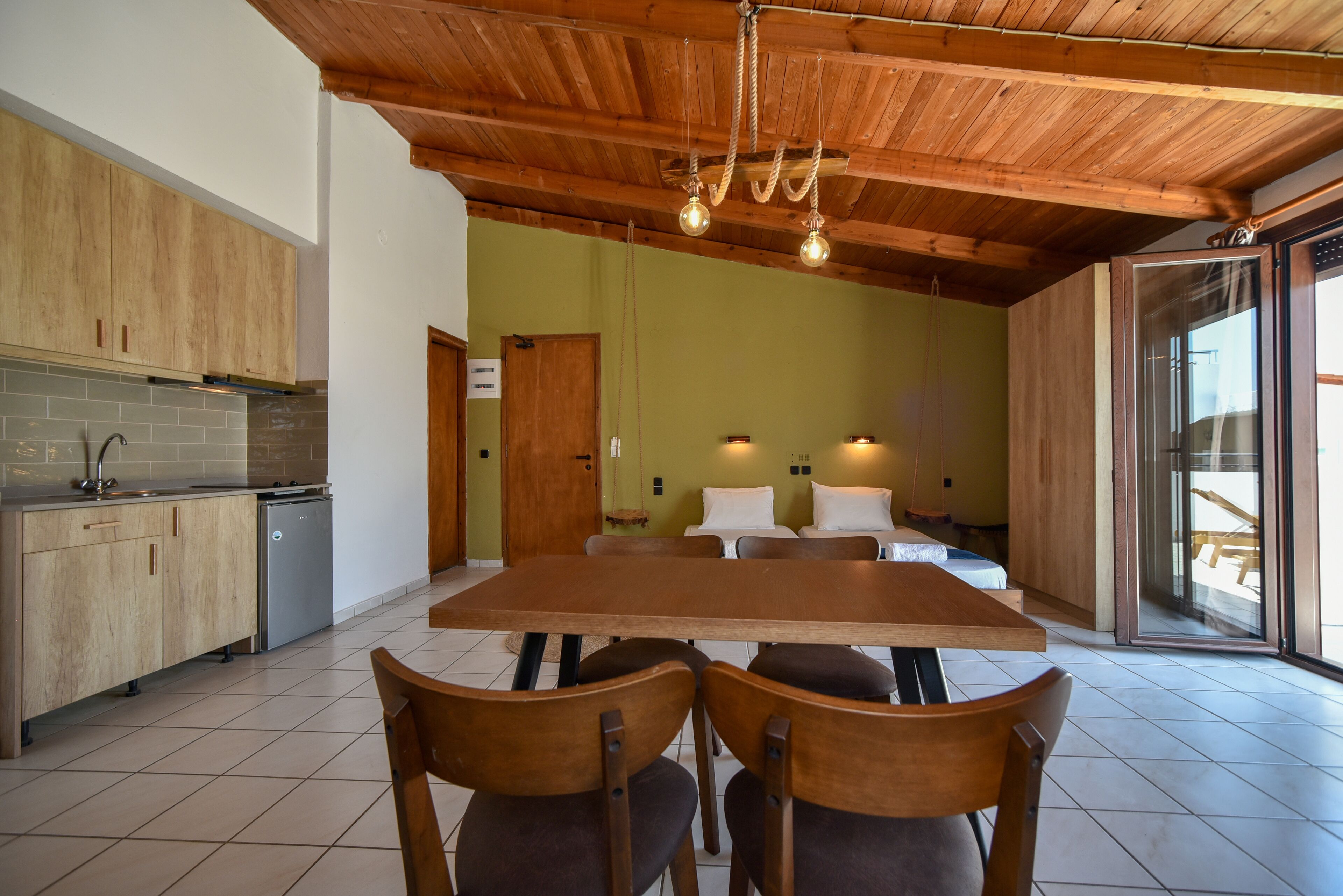 Een moderne keuken met houten kastjes, een eettafel en stoelen.