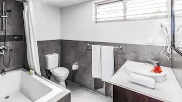 A modern bathroom with a bathtub, toilet, and sink.