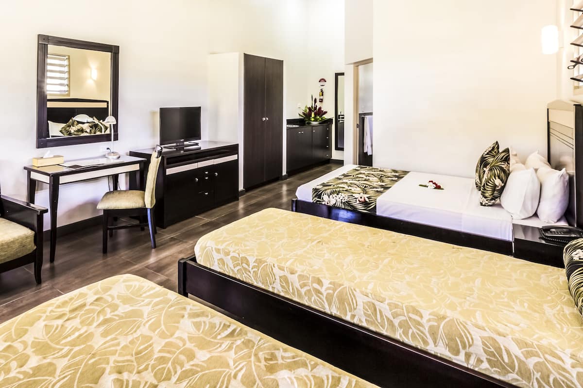 A hotel room with a bed, a desk, a chair, a wardrobe, and a bathroom.