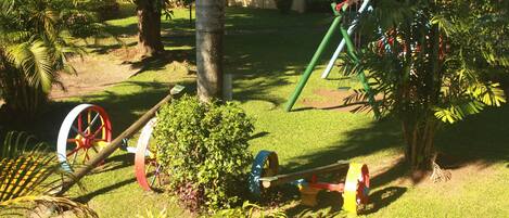 A playground with swings, a slide, and a seesaw.