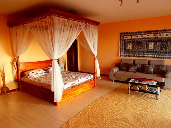 Una habitación con una cama con dosel, un sofá y una mesa de centro.